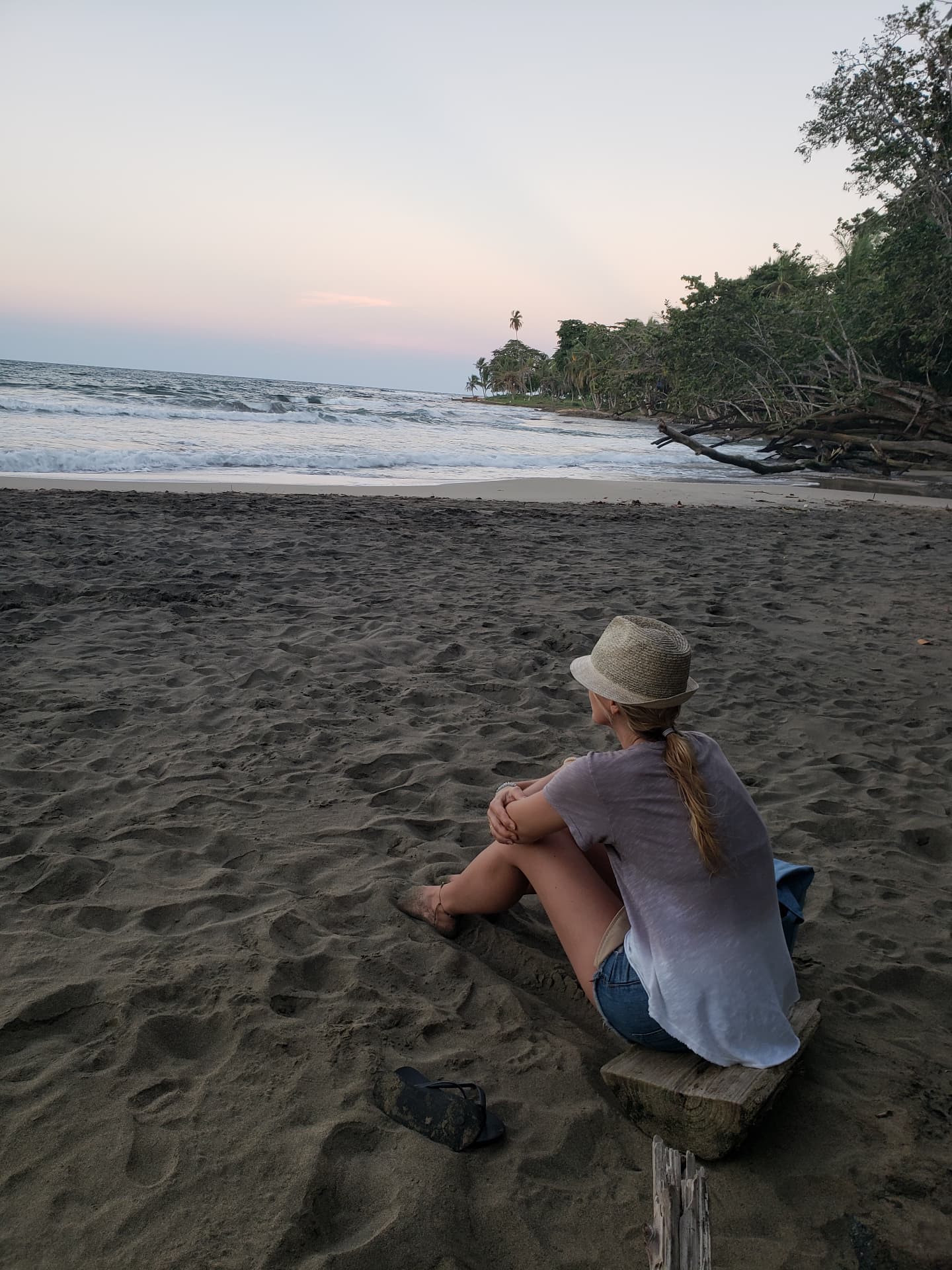 Christina sitting quietly beside the ocean at dusk