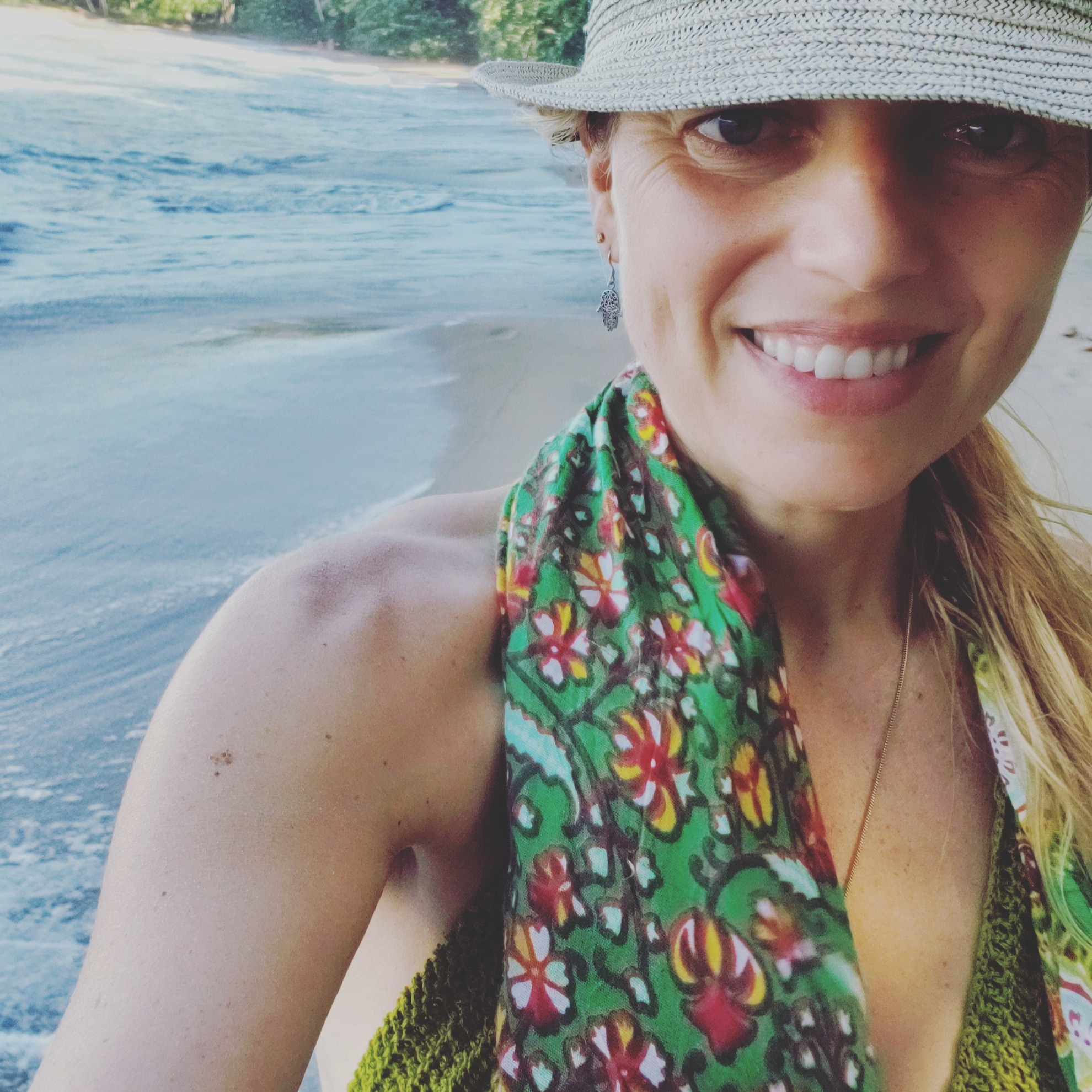 Christina smiling beside the sea on a tropical coast