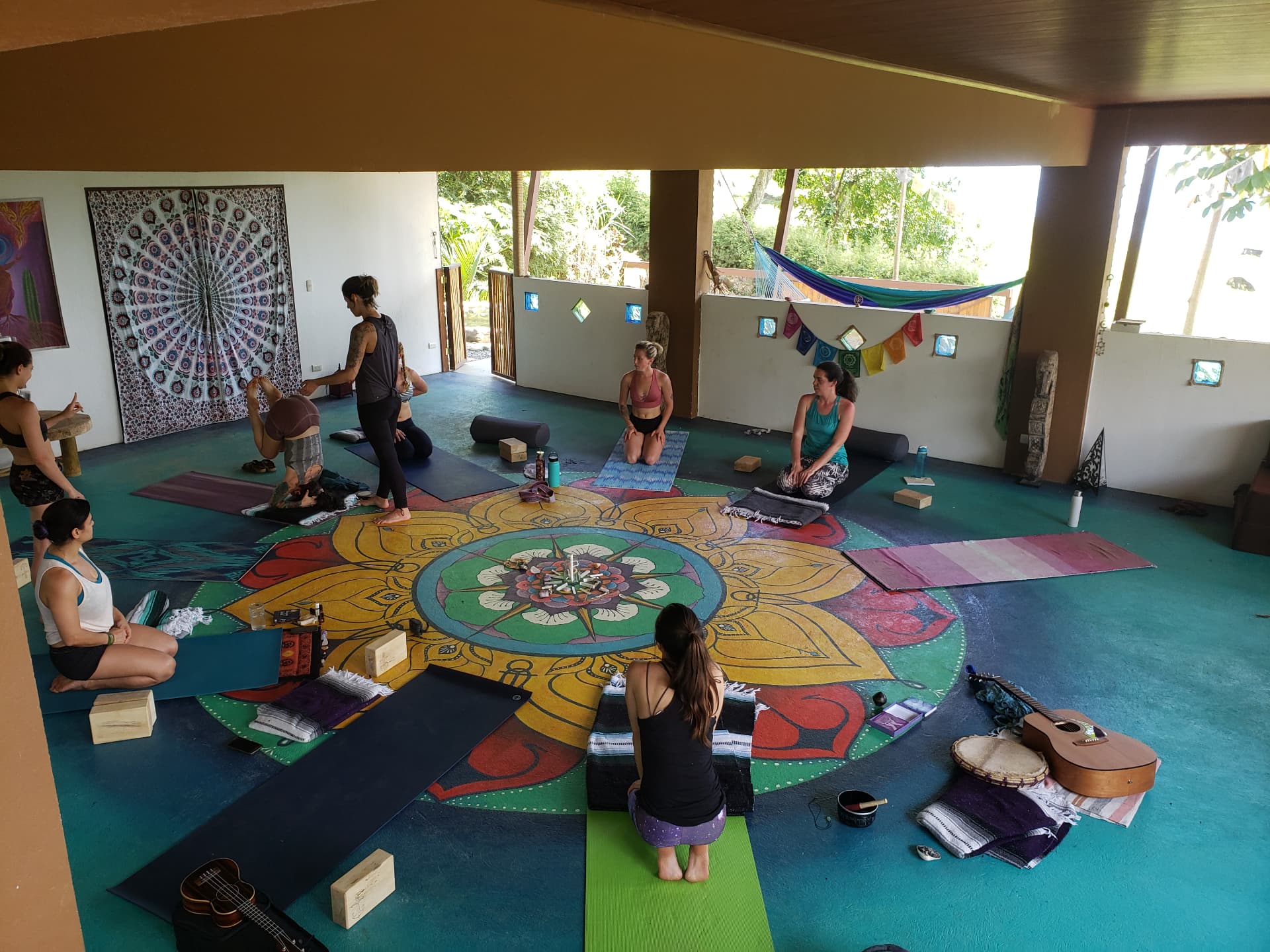 A yoga circle gathered around a hand-painted mandala